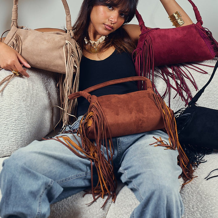 Suede fringe bags on a sofa