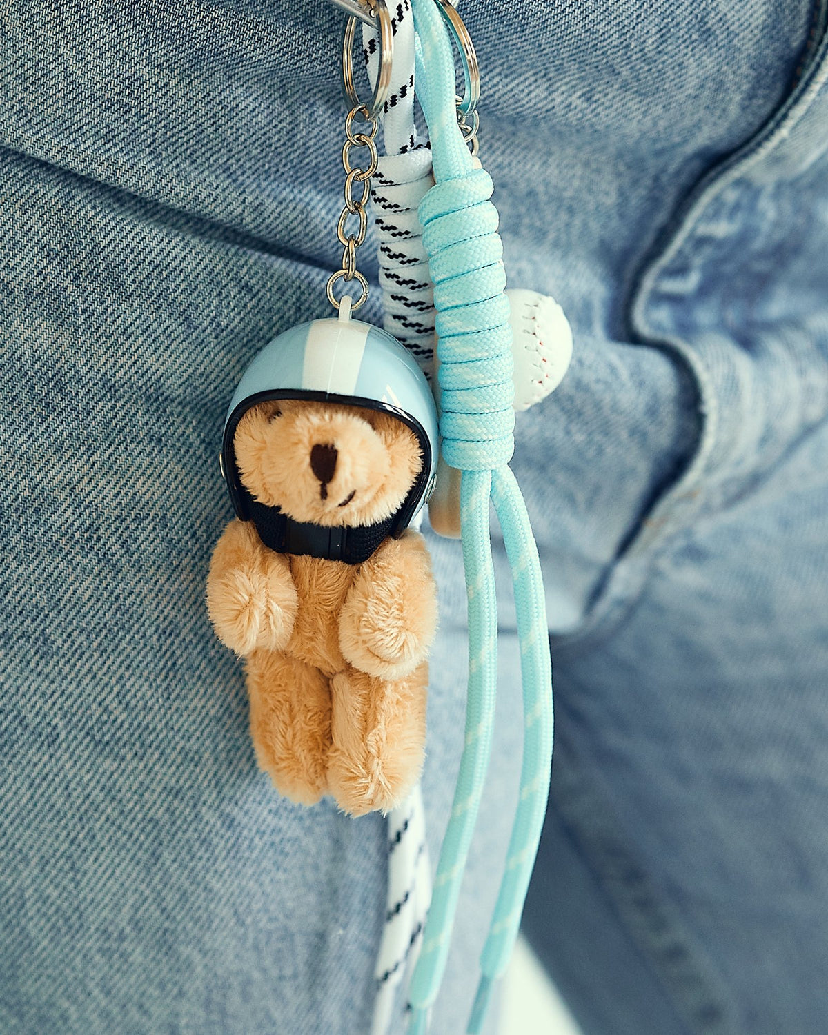 Sky bear bag charm with helmet clipped to jeans